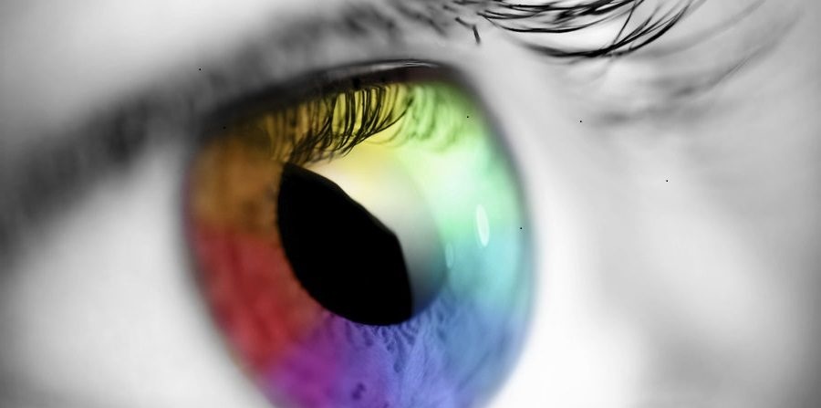 black and white close up of an eye with rainbow coloured iris